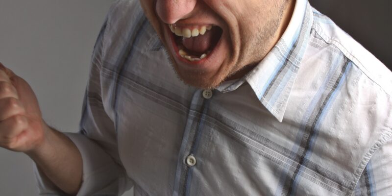 A man screaming in frustration from his pain.