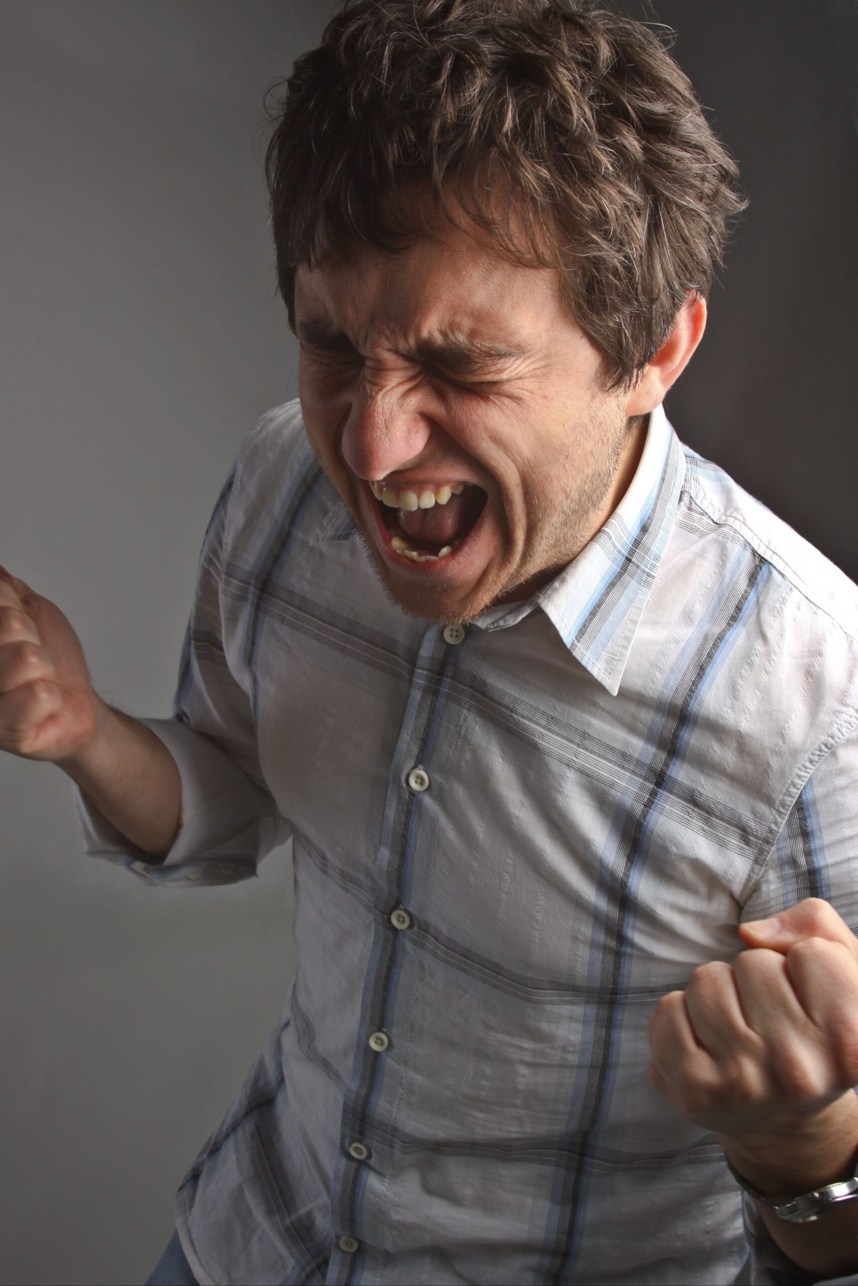 A man screaming in frustration from his pain.